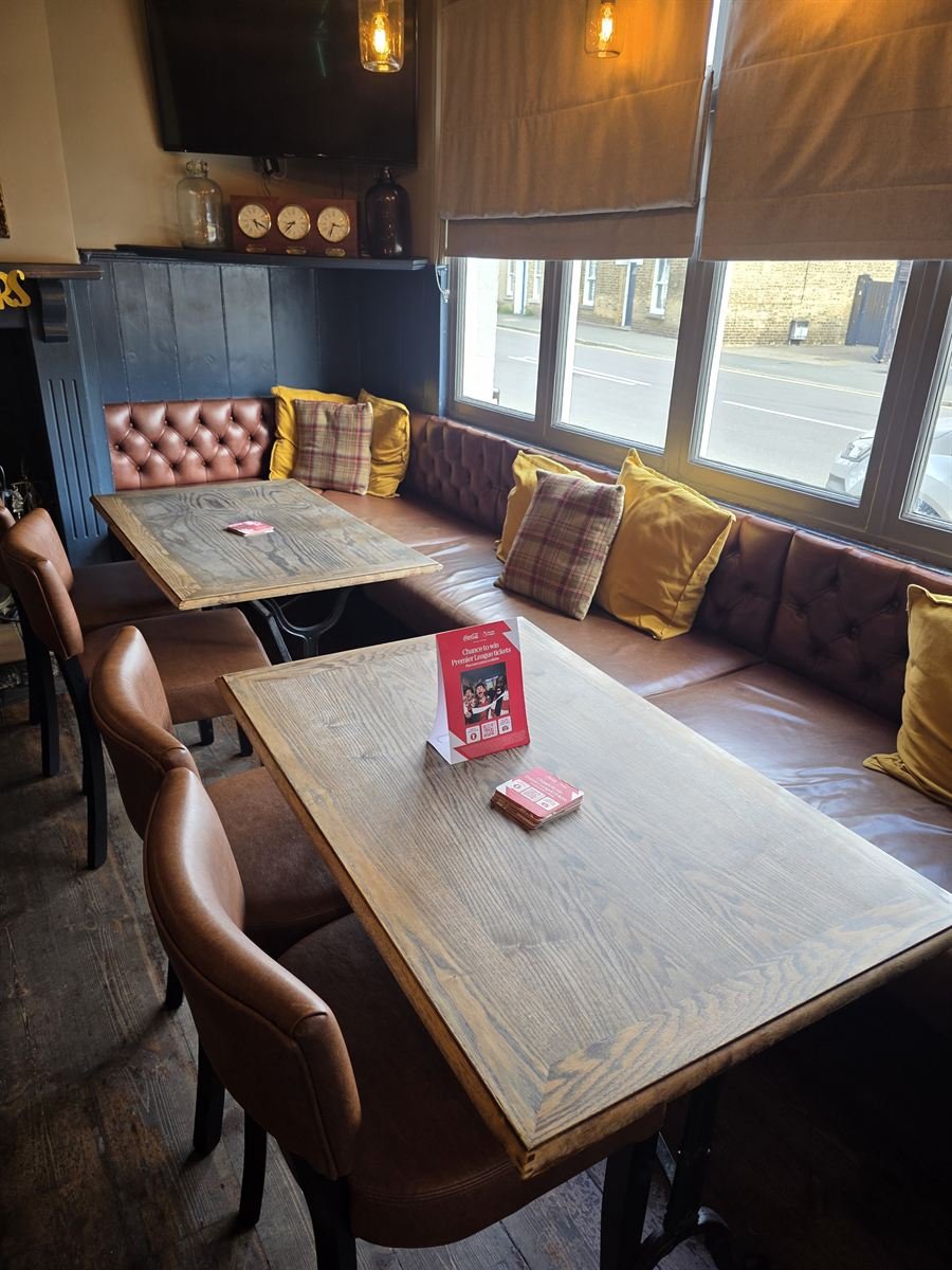 Window seats on a long leather banquette looking out onto the High Street